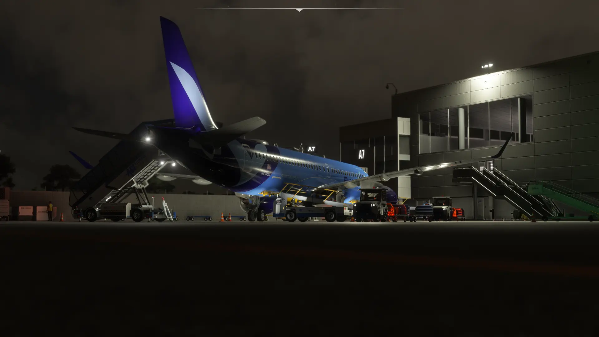 Breeze A220 parked beside an illuminated terminal at night in flight simulator